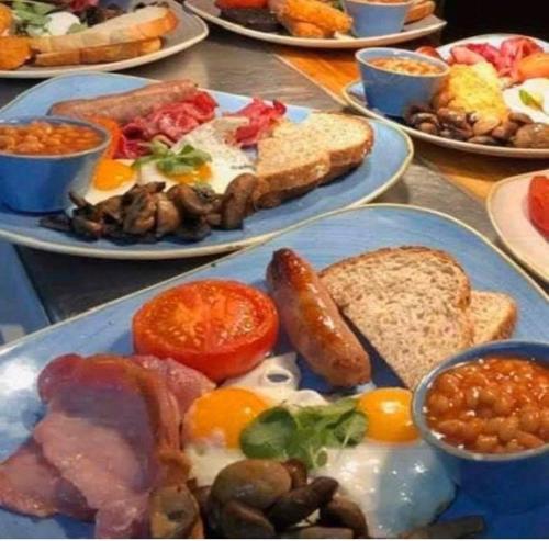 a table full of plates of breakfast food with eggs and bread at The Beulah Apartments in Leeds