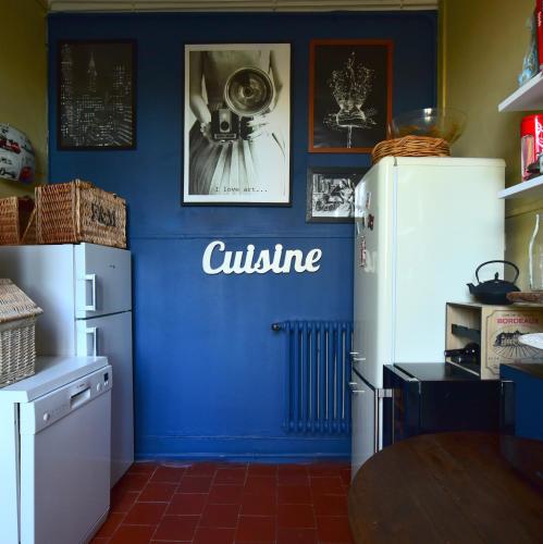 a kitchen with a blue wall with a white refrigerator at CHATEAU ROUTGER in Sainte Marie de Gosse