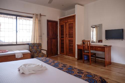 um quarto com uma secretária e uma cama e uma secretária em Nungwi Heritage Resort em Nungwi