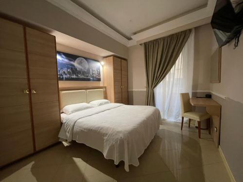 una camera con letto, scrivania e finestra di Ambasada Suite a Roma