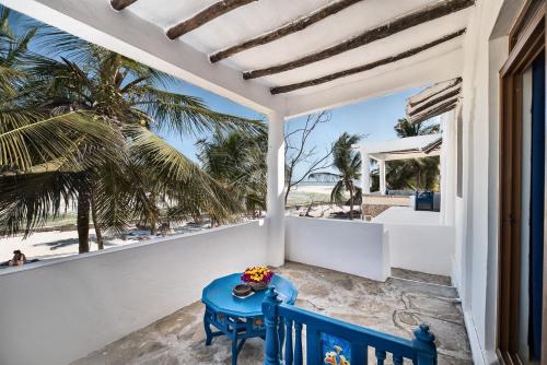 a blue table on a balcony with a view of the beach at Jacaranda Beach Resort in Watamu