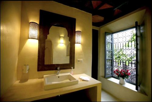 uma casa de banho com um lavatório, um espelho e uma janela em BKAN RIAD MARRAKECH em Marrakech