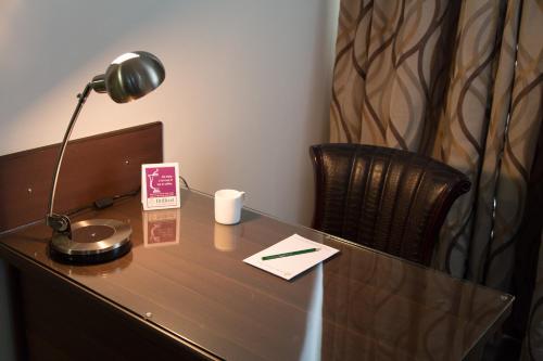 an office desk with a lamp and a chair at Brilliant Hotel & Convention Centre Indore in Indore