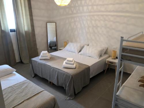 a bedroom with two beds with towels on them at B&B BELLAMI' in Tuglie