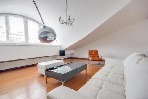 a living room with a white couch and a table at Royal Wawel Castle Luxury Apartment in Krakow