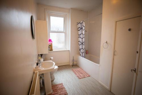 ein Bad mit einem Waschbecken, einem WC und einem Fenster in der Unterkunft Lovely Apartment in Old Walker