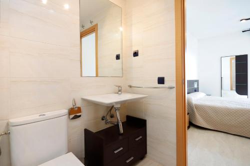 ein Bad mit einem Waschbecken, einem WC und einem Bett in der Unterkunft AT259 Costa Coral in Torredembarra