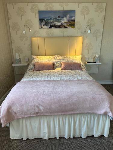 a bedroom with a large bed with two pillows at Crossroads in Holyhead