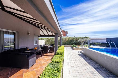 a patio with a couch and a swimming pool at Villa Enna with heated pool, Zadar in Crno