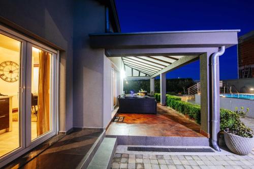an external view of a house with a patio at Villa Enna with heated pool, Zadar in Crno