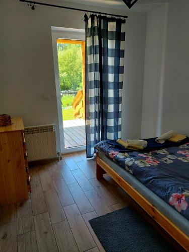a bedroom with a bed and a sliding glass door at Do Słońca in Ropienka