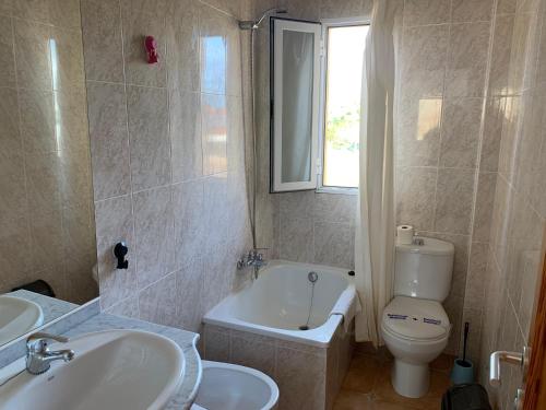 ein Badezimmer mit einer Badewanne, einem WC und einem Waschbecken in der Unterkunft Kione Anamar in Alcossebre