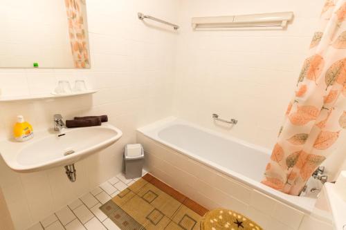 a bathroom with a sink and a tub and a toilet at Ferienwohnung Kratzer in Waltenhofen