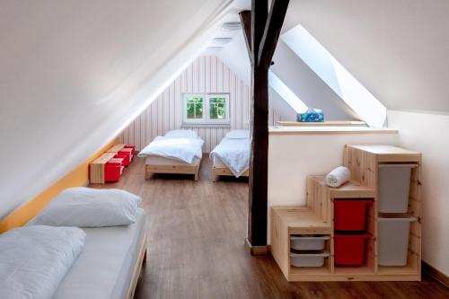 a attic bedroom with two beds and a mirror at Vila Tess in Lázně Libverda