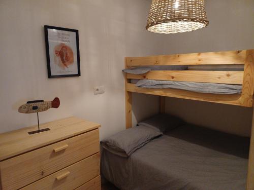 ein Schlafzimmer mit einem Etagenbett und einer Lampe in der Unterkunft Apto 1a línea del Paseo Llafranc con Aire acondicionado Sin Vistas in Llafranc