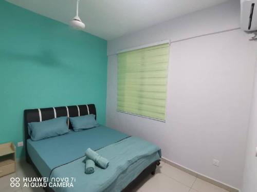 a bedroom with a bed with blue walls and a window at HK Homestay in Ipoh