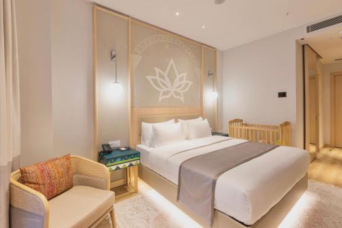 a bedroom with a large bed and a chair at Hilton Garden Inn Samarkand Sogd in Samarkand