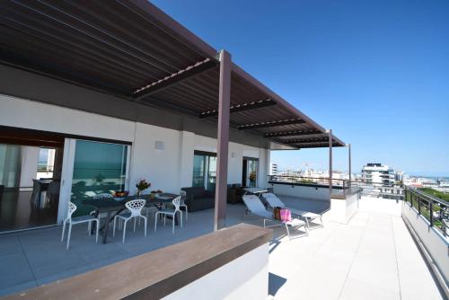 een balkon van een gebouw met een tafel en stoelen bij Aparthotel Alessandria in Lignano Sabbiadoro