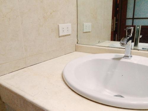 a bathroom with a white sink and a mirror at Chinatown Lai Lai Hotel Inc in Manila