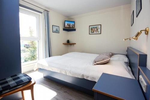 a bedroom with a large bed and a window at Yachthafenresidenz-Wohnung-9310-900 in Kühlungsborn