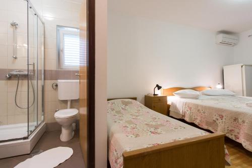 a bathroom with two beds a toilet and a shower at Bed & Breakfast Mario in Krk