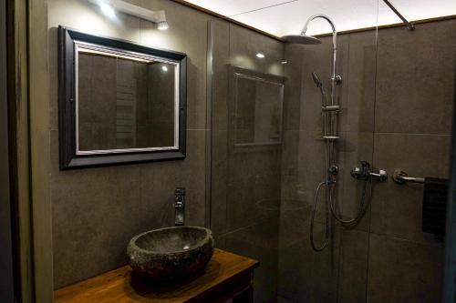a bathroom with a bowl sink and a shower at Les Jardins de la Contie in Lunan