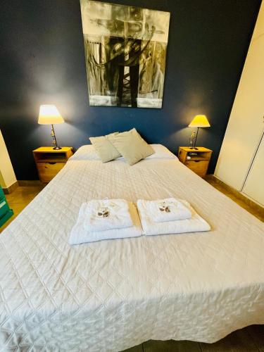 a bedroom with a white bed with towels on it at Jujuy Downtown suite WIIFI in San Salvador de Jujuy