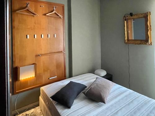 1 dormitorio con 1 cama con 2 almohadas en Living in the archeosites - Rental Apartments, en Siracusa