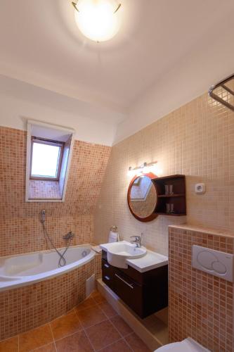a bathroom with a tub and a sink and a bath tub at Angyal Panzió in Hajdúszoboszló