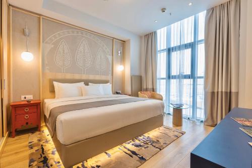 a bedroom with a large bed and a large window at Hilton Garden Inn Samarkand Sogd in Samarkand