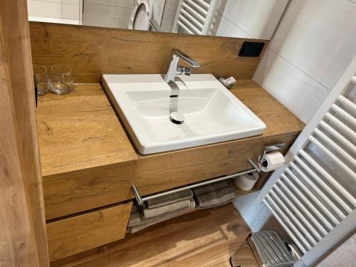 ein Badezimmer mit einem weißen Waschbecken und einem Spiegel in der Unterkunft Laupus-Hof in Bad Vilbel