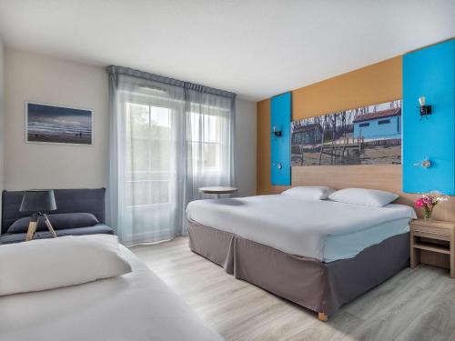 ibis Styles Marennes d'Oléron في مارينيس: غرفة فندقية بسريرين ونافذة