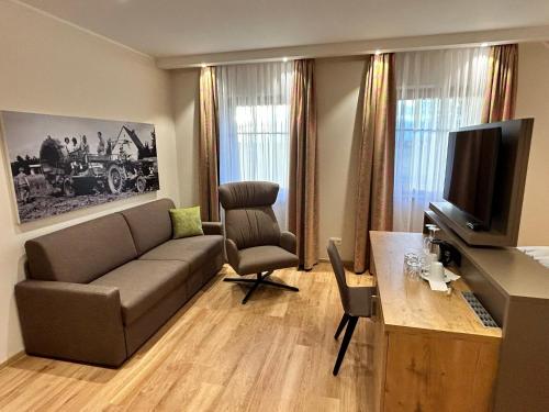 ein Wohnzimmer mit einem Sofa und einem TV in der Unterkunft Laupus-Hof in Bad Vilbel