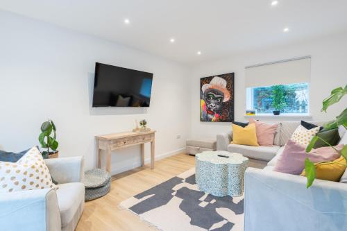 uma sala de estar com dois sofás e uma televisão em The Pinkish House - 4 bed home in the town centre em Blairgowrie