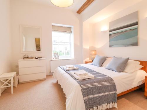 a bedroom with a large white bed and a window at Feathers, Blythburgh in Halesworth