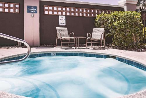 a small swimming pool with chairs and a table at La Quinta by Wyndham Las Vegas Summerlin Tech in Las Vegas