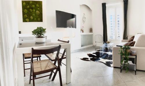 a white living room with a table and chairs at Cosy T2 in Neuilly sur Seine metro 1 in Neuilly-sur-Seine