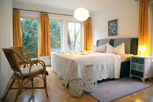 a bedroom with a bed with a chair and a window at Ferienwohnungen an den Salzwiesen in Boltenhagen