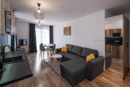 a living room with a couch and a table at Apartamenty Sun & Snow Resorts D Białka Tatrzańska z sauną in Białka Tatrzańska