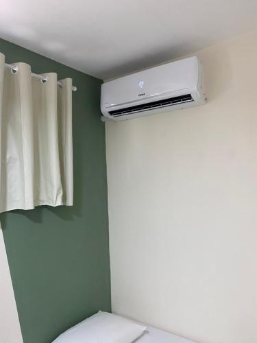 a bathroom with a toilet and a air conditioner at Casa aconchegante e charmosa à 6 min da Praia - Ar condicionado - WIFI 600MB - Netflix - Globoplay - Cozinha Completa in Rio das Ostras