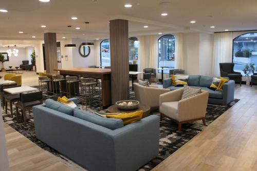 a lobby with couches and chairs and a table at La Quinta Inn & Suites by Wyndham Santa Cruz in Santa Cruz