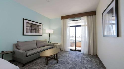 a living room with a couch and a table at La Quinta Inn & Suites by Wyndham Santa Cruz in Santa Cruz
