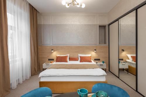 a bedroom with a large bed and two chairs at Jam Apartments Miskevycha in Lviv