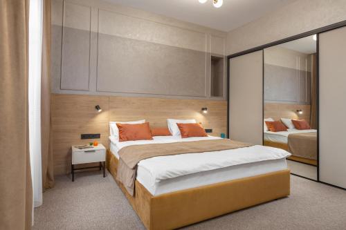 a bedroom with a large bed with orange pillows at Jam Apartments Miskevycha in Lviv