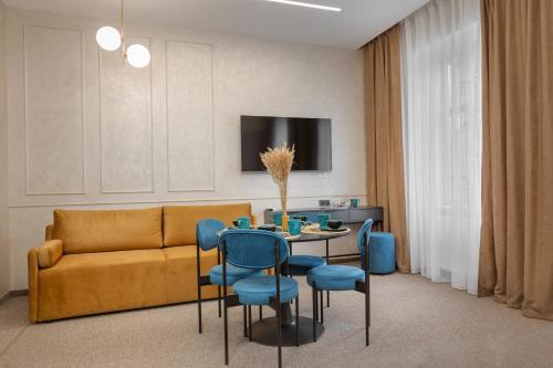 Jam Apartments Lviv في إلفيف: غرفة معيشة مع أريكة وطاولة وكراسي