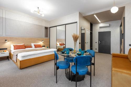ein Hotelzimmer mit einem Bett, einem Tisch und Stühlen in der Unterkunft Jam Apartments Lviv in Lwiw