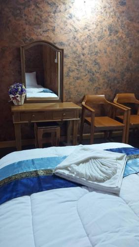 a bedroom with a bed with a mirror and a desk at กอบสุข รีสอร์ท2 k12 in Ban Ton Liang