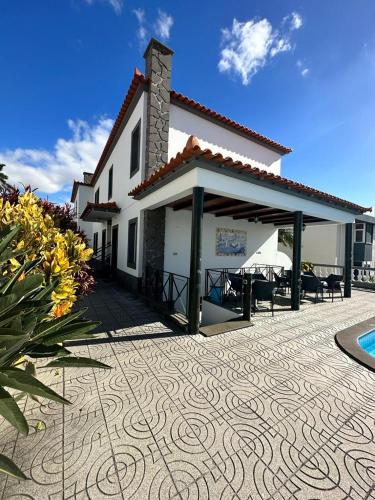 a white house with a patio and a swimming pool at Valhalla Panorama in Funchal