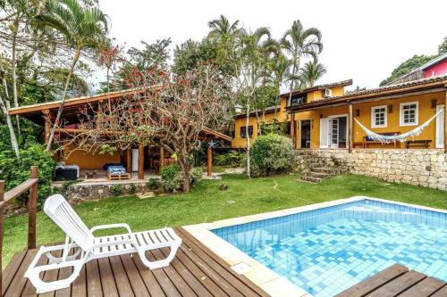 un patio trasero con piscina y una casa en llhabela incrível vista e piscina, en Ilhabela