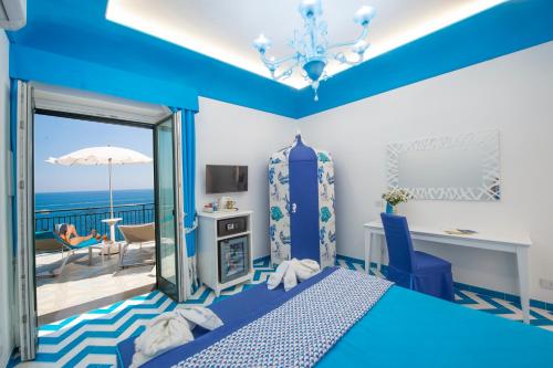 a blue bedroom with a view of the ocean at Hotel Villa Maria Pia in Praiano